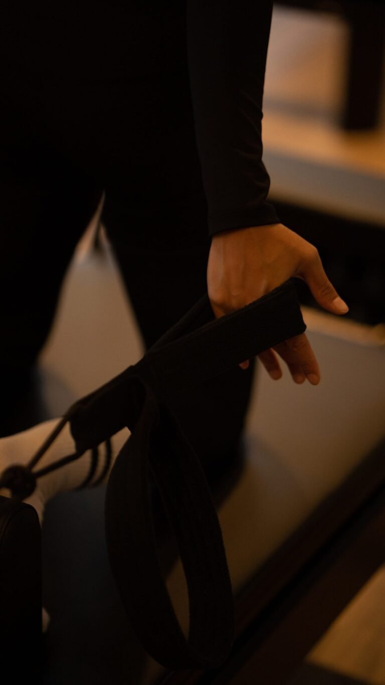 A member's hand gripping a reformer strap